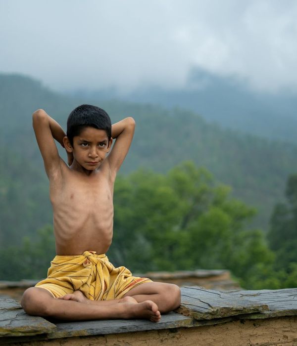 Person meditating peacefully outdoors with nature in the background.